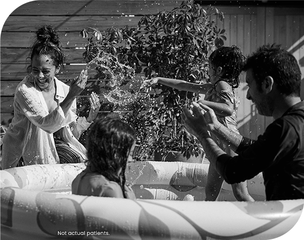 People playing in an inflatable pool in a yard